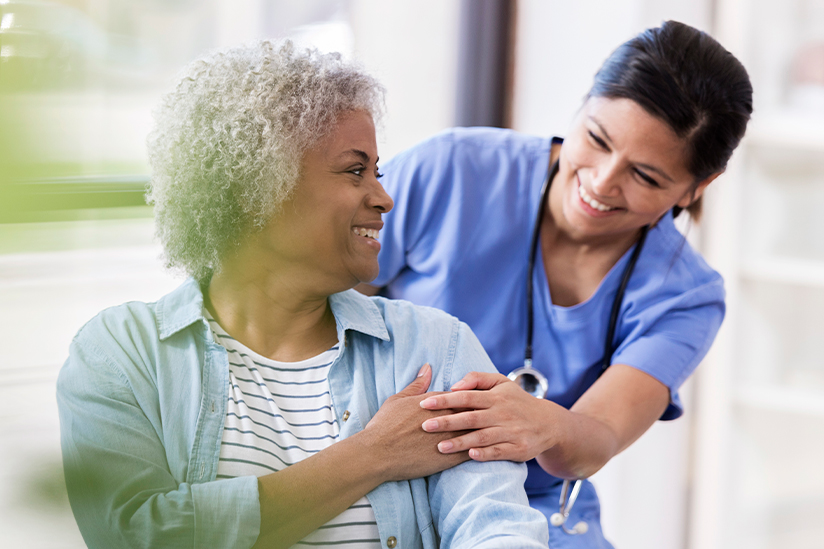 Nurse providing compassionate care to woman sitting.