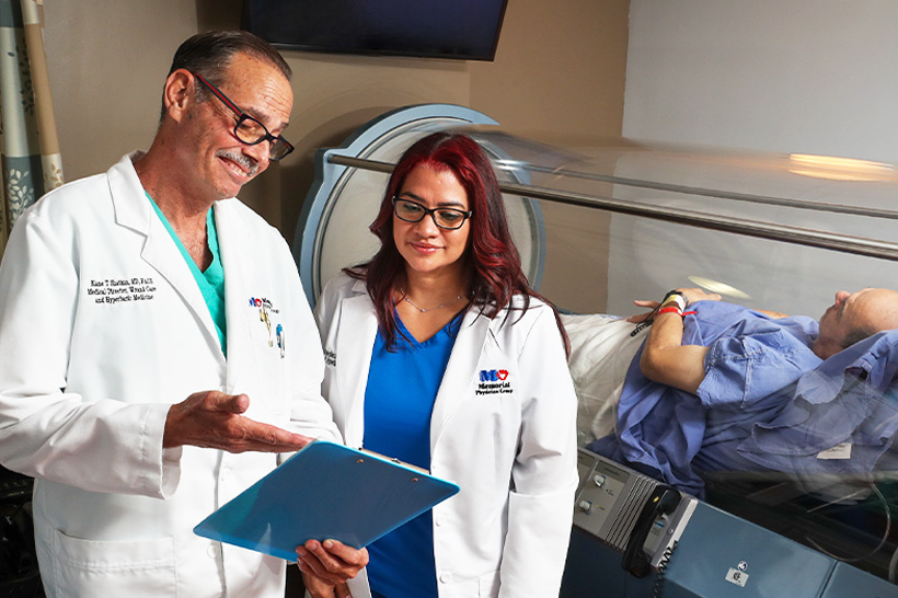 Blaine Shatkin, MD and nurse consult on patient in hyperbaric chamber